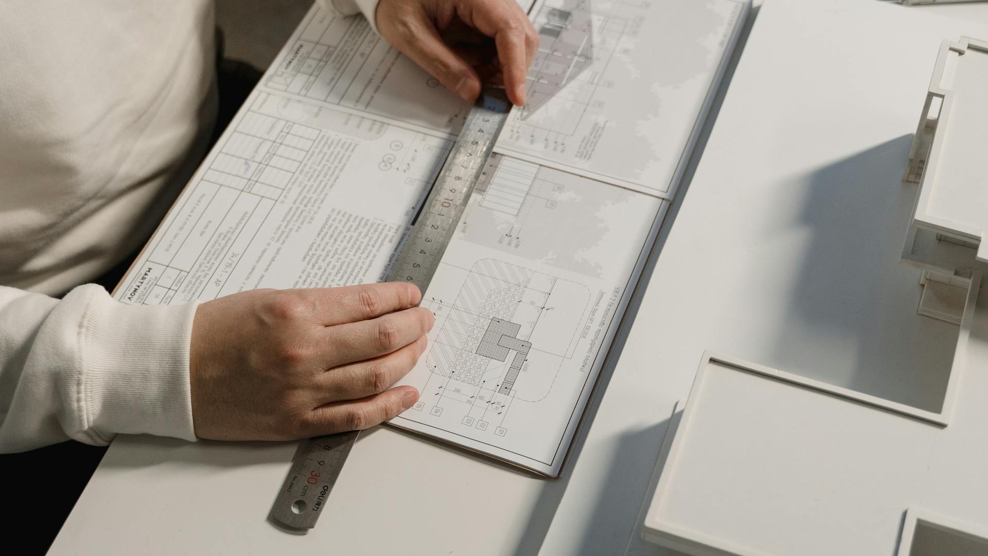 Architect reviewing blueprints with ruler